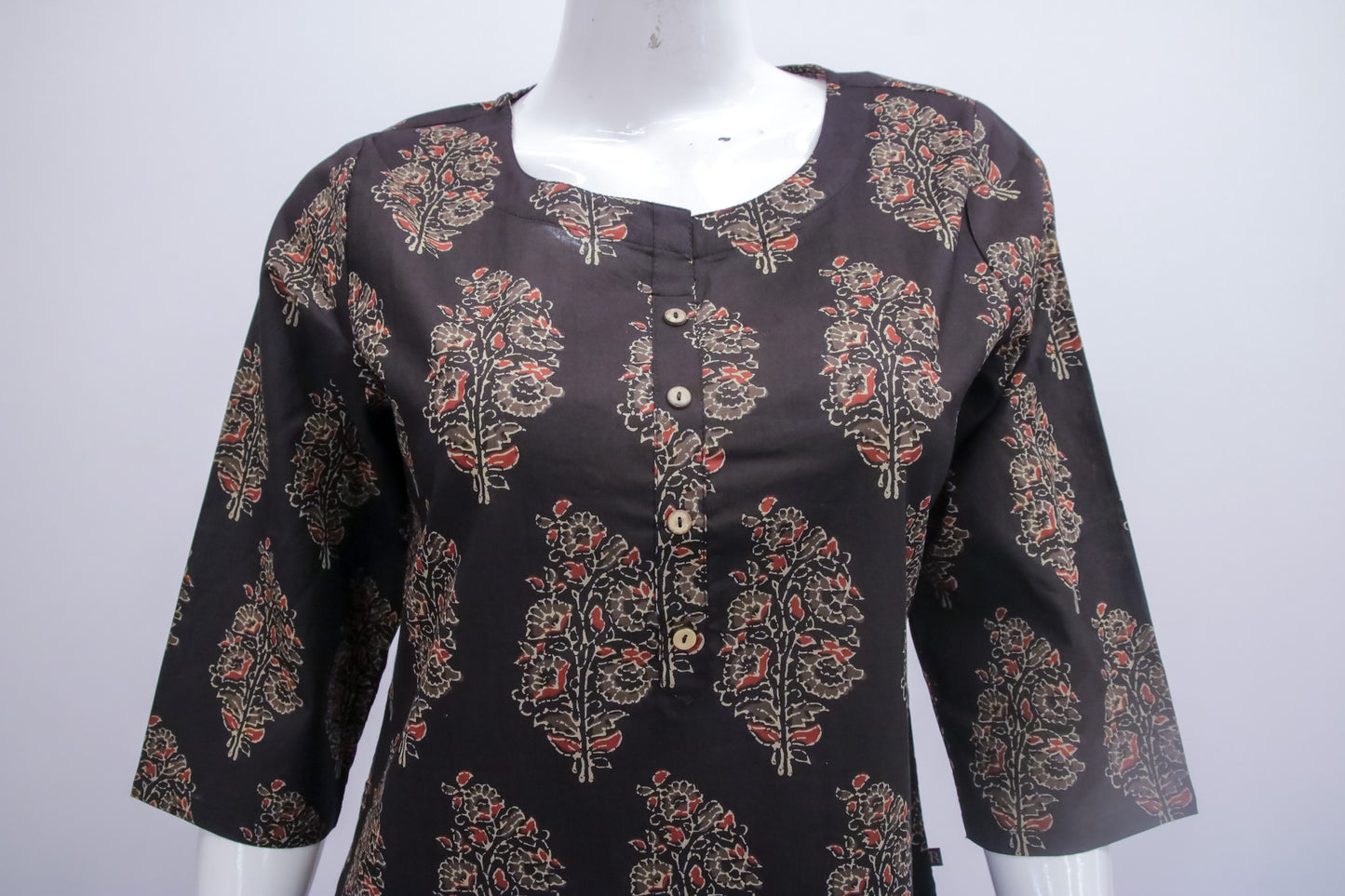 Black floral patterned blouse on a mannequin against a white background