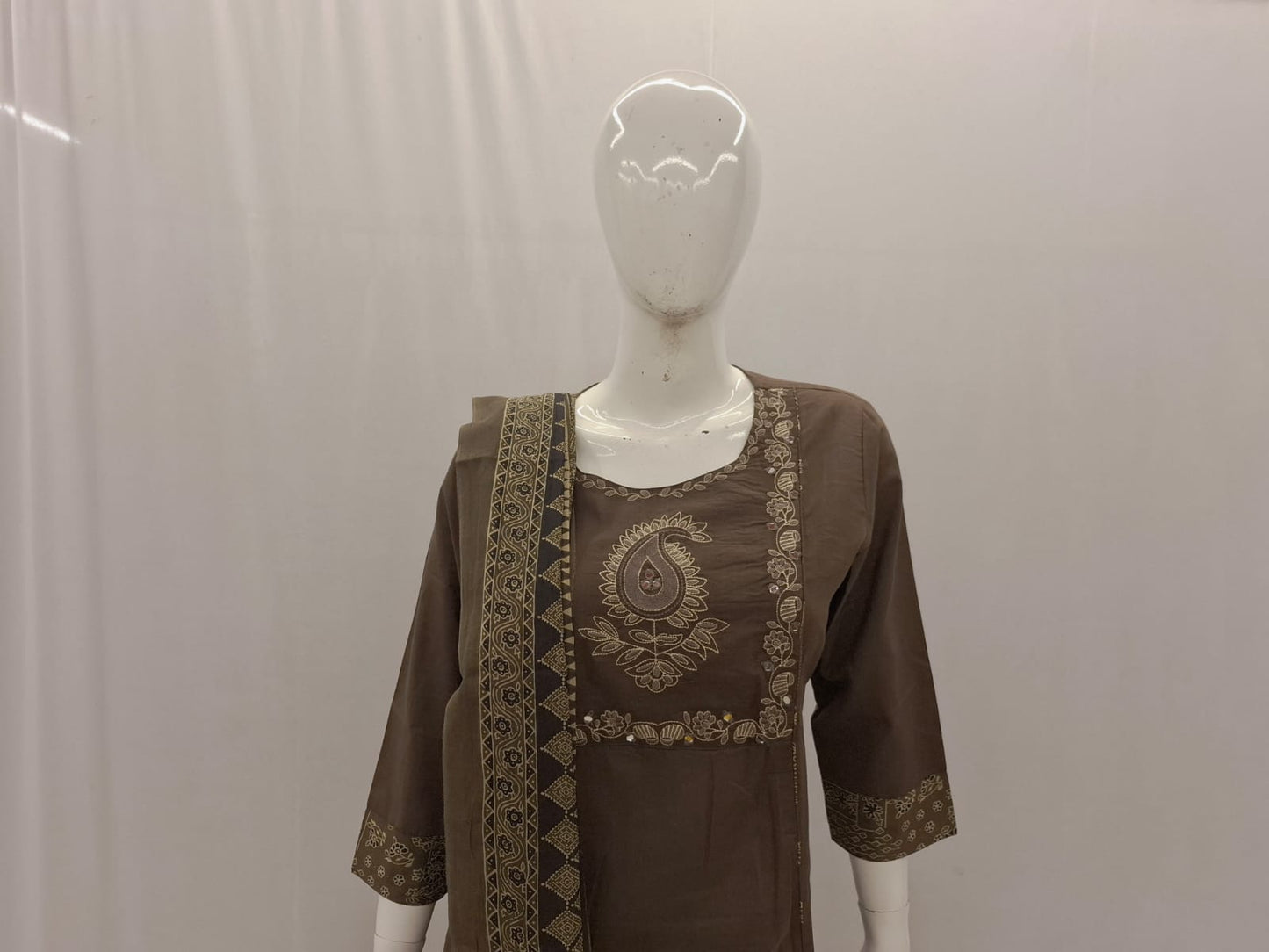 Brown embroidered top on a mannequin against a plain background