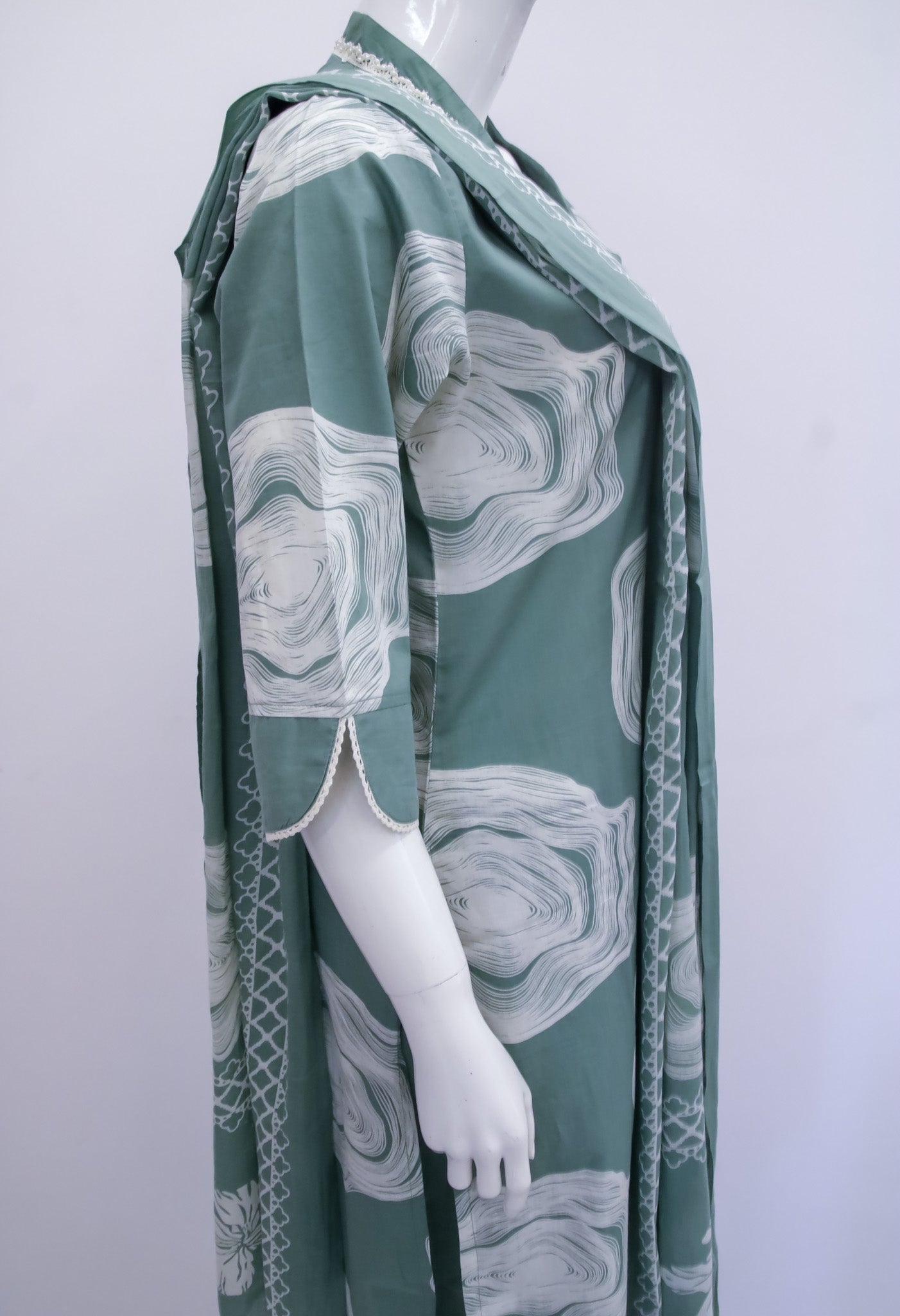 Mannequin wearing a green dress with abstract pattern on a white background