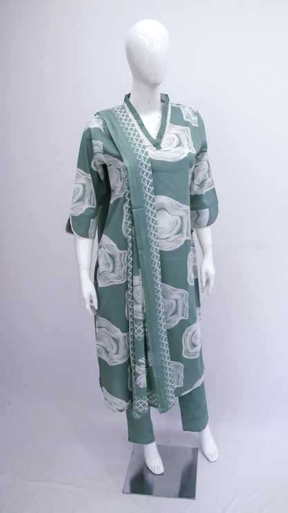 Green and white patterned dress on a mannequin against a white background