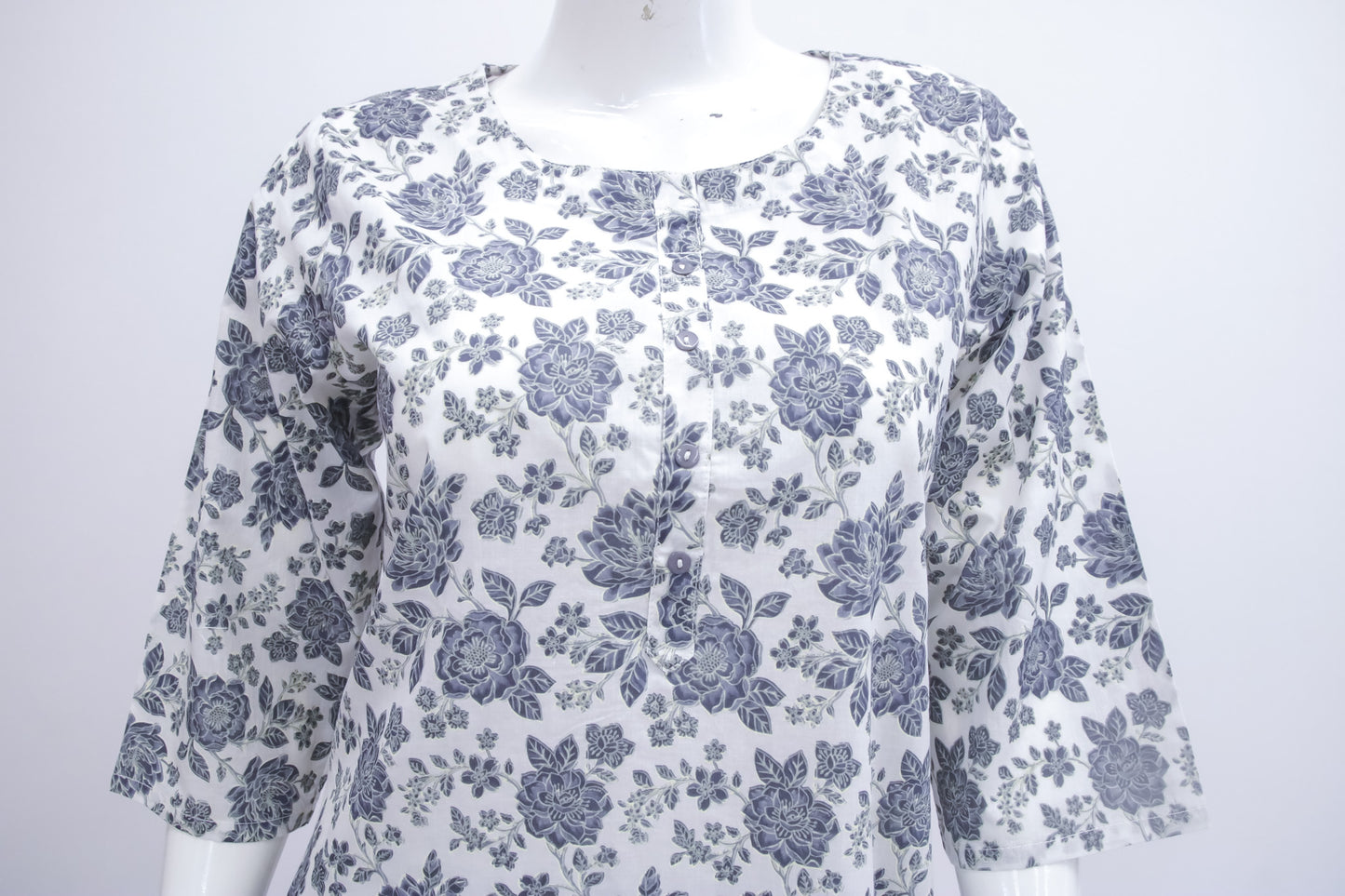 White blouse with blue floral pattern on a mannequin against a white background