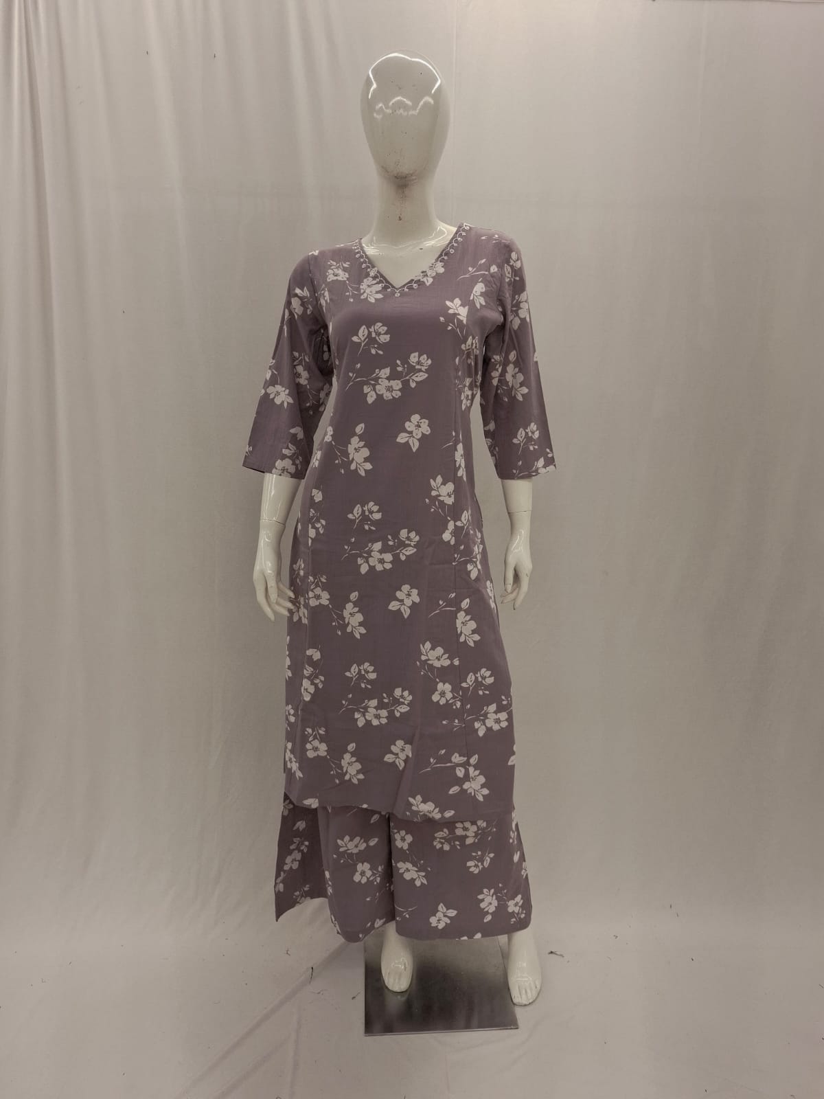 Purple floral dress on a mannequin against a plain background