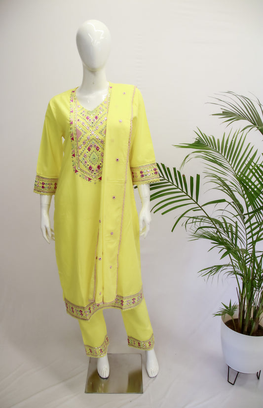 A light yellow dupatta set displayed on a mannequin, featuring embroidery and lace work, with a V-neck dupatta and straight-cut kurta and pant.