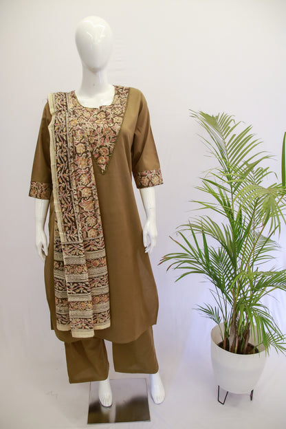 A mannequin displaying a green and beige traditional Indian cotton Mehndi dupatta set with embroidery, alongside a potted plant.