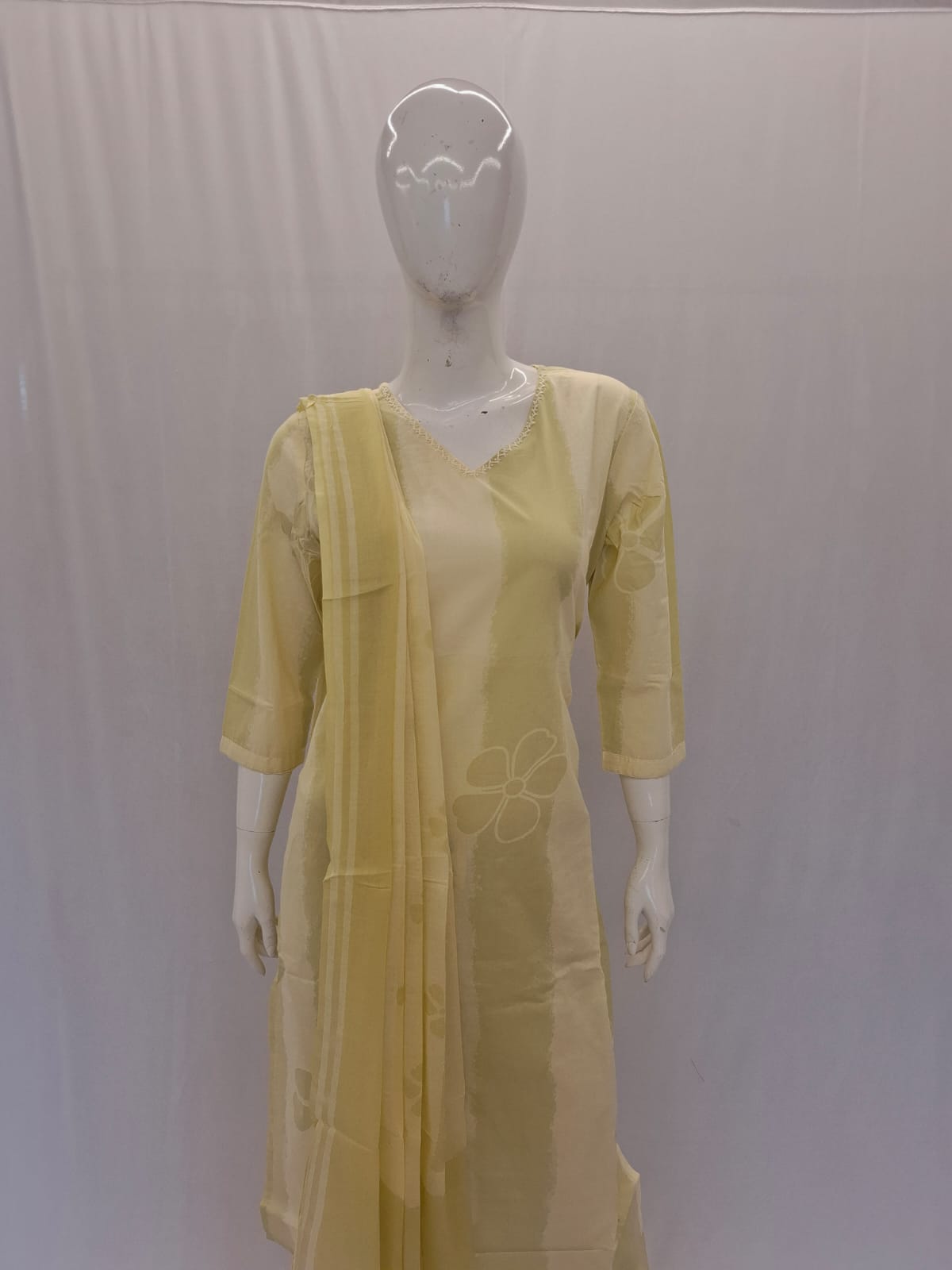 Yellow kurta with a matching dupatta on a mannequin against a plain background