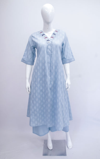 Light blue polka dot dress with floral embroidery on a mannequin against a white background
