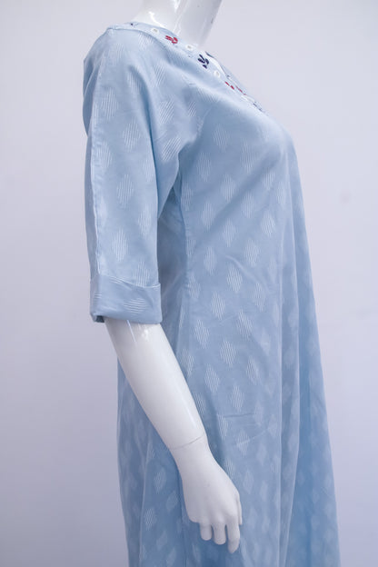 Mannequin wearing a light blue hospital gown on a white background