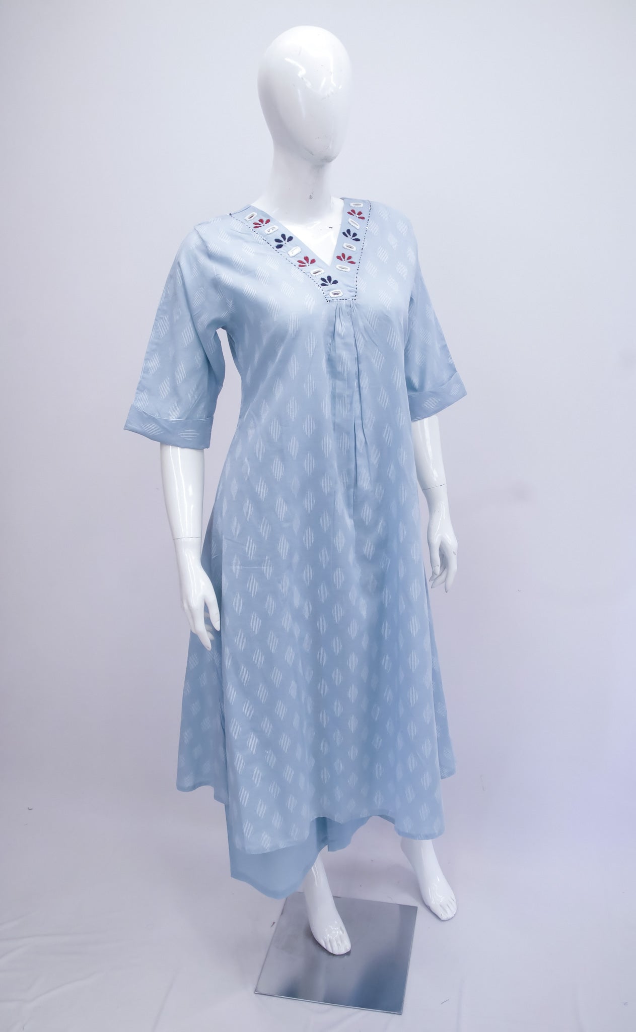 Light blue dress with floral embroidery on a mannequin against a white background