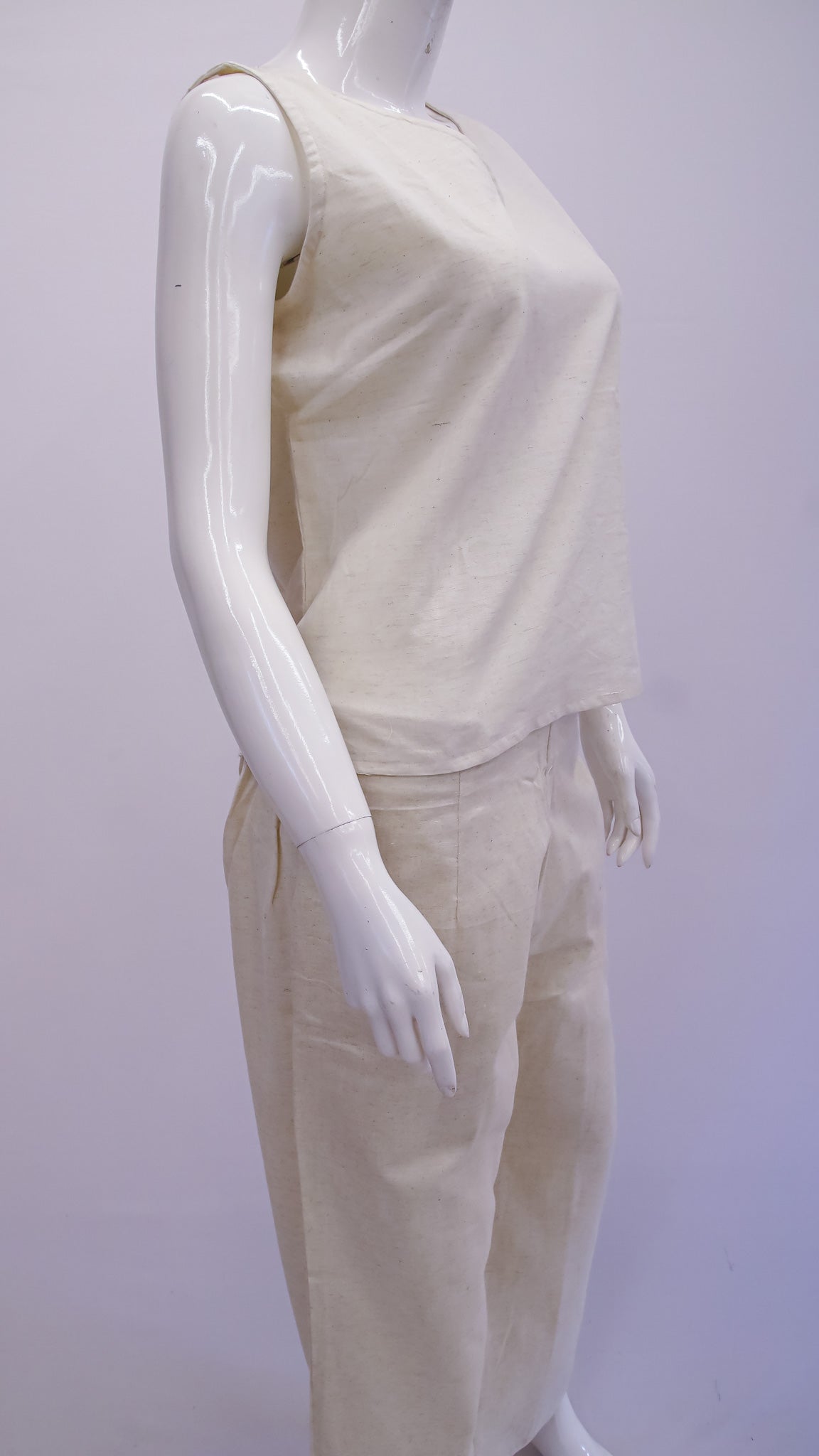 Mannequin wearing a beige top and pants set against a white background