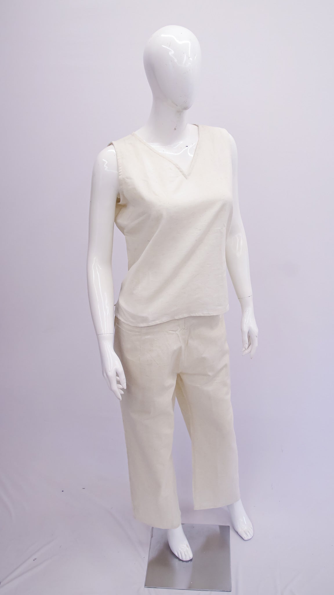 Mannequin wearing a white sleeveless top and pants on a white background