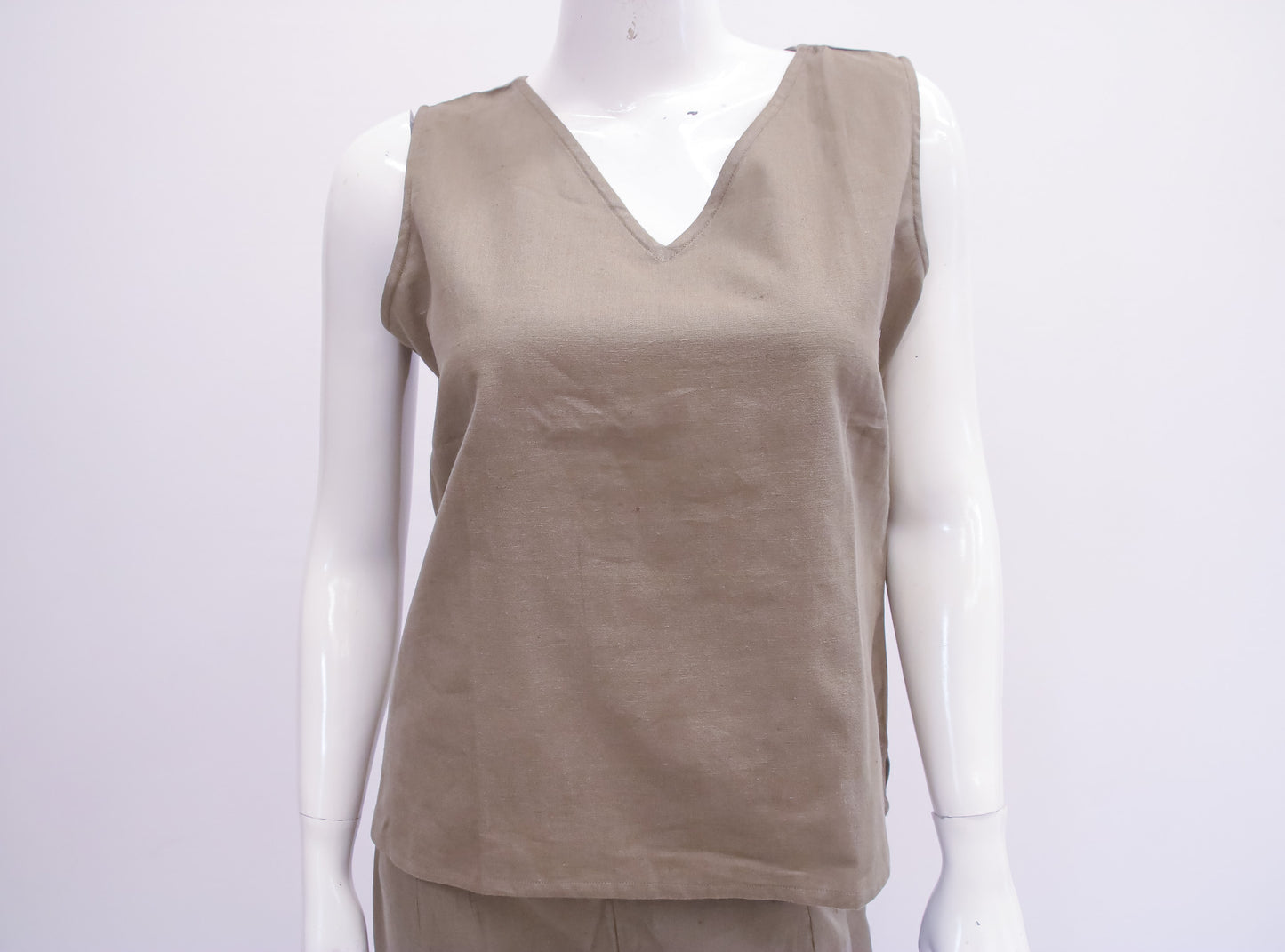Beige sleeveless top on a mannequin against a white background