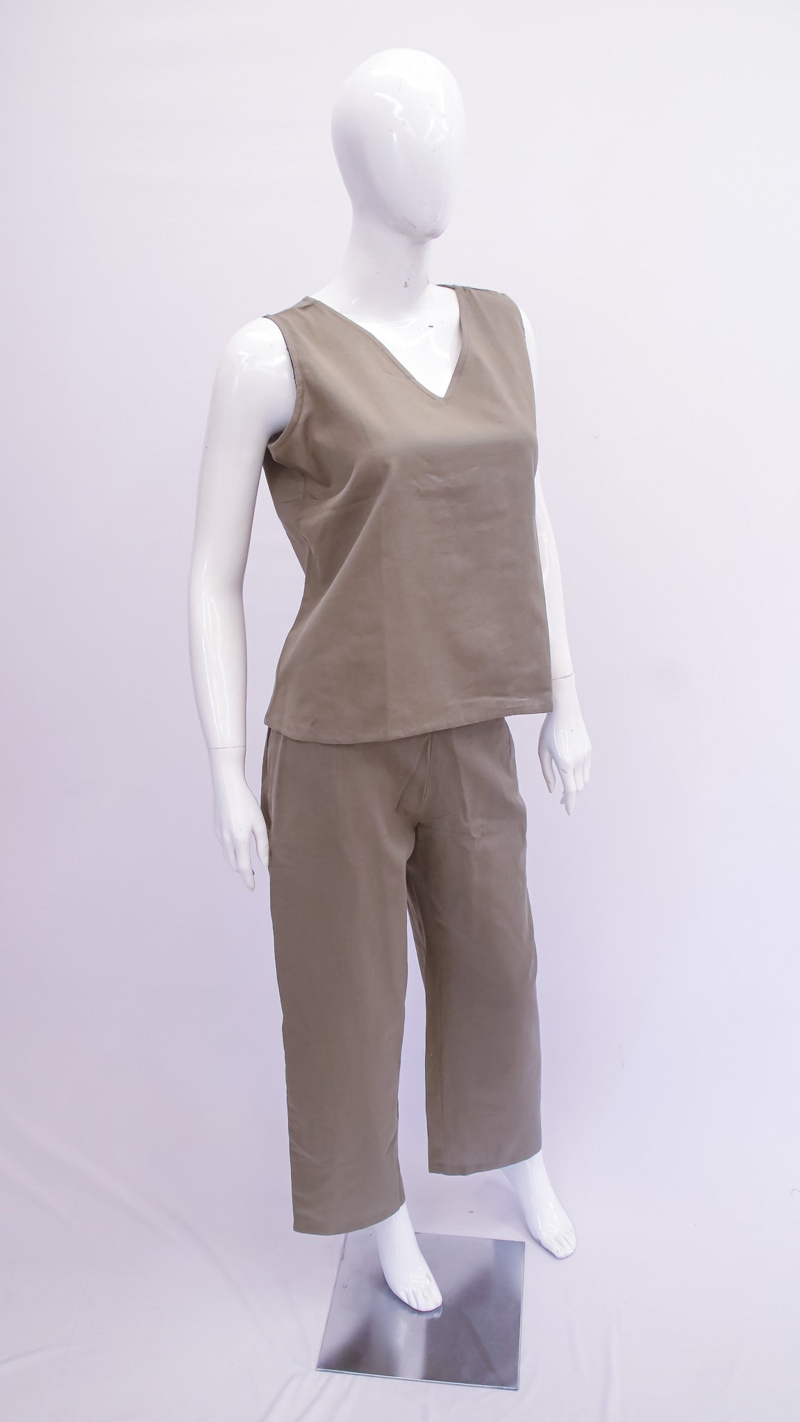 Mannequin wearing a beige sleeveless top and pants on a white background