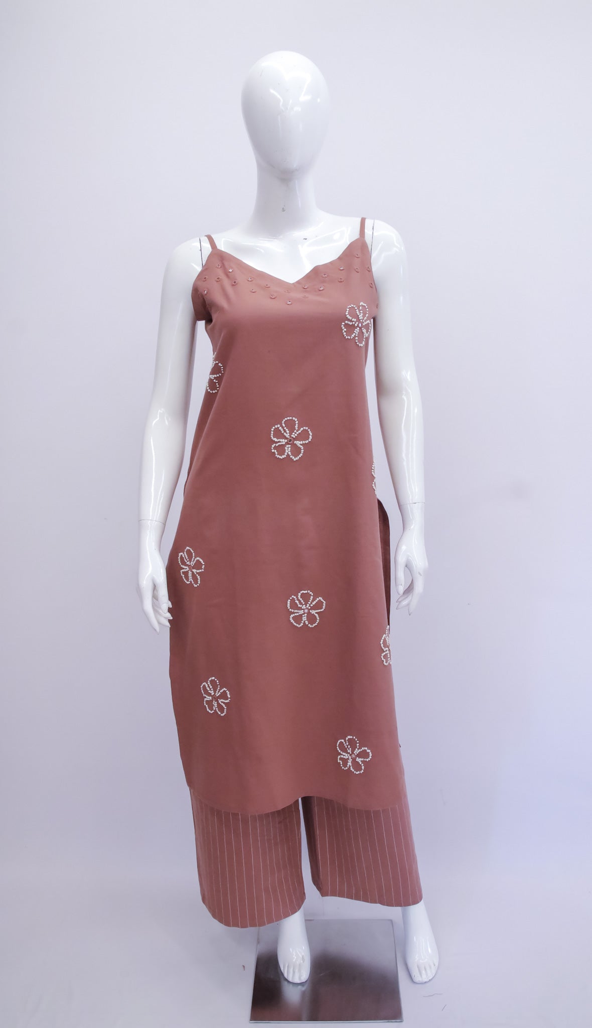 Mannequin wearing a brown dress with floral patterns on a white background