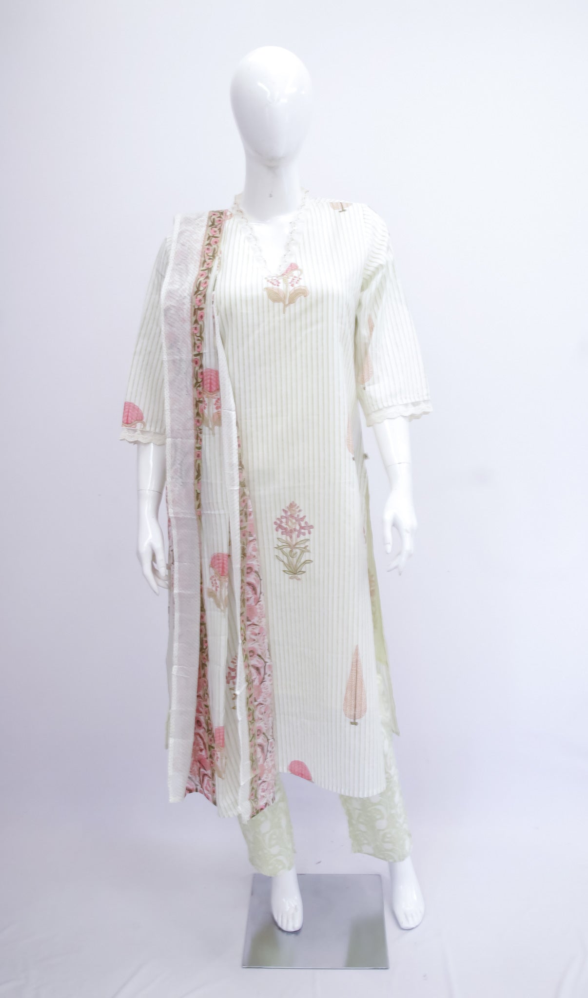 Mannequin wearing a white outfit with floral patterns on a white background