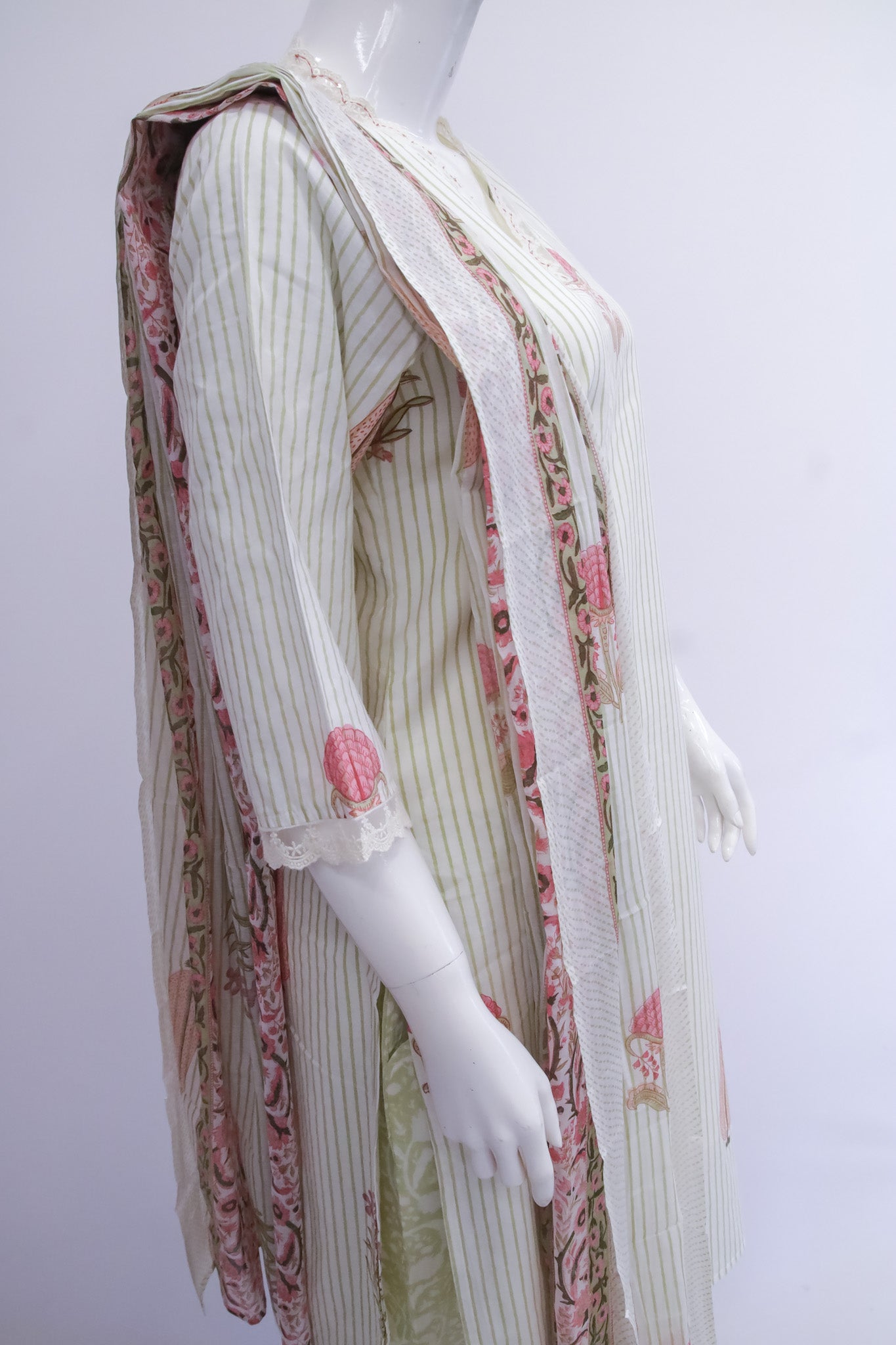 Mannequin wearing a traditional outfit with a white and pink patterned shawl on a white background