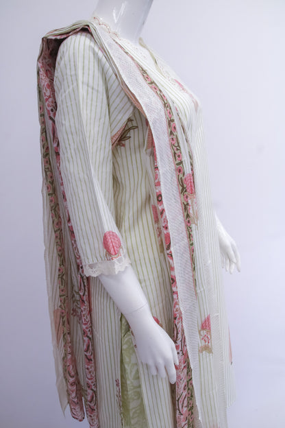 Mannequin wearing a traditional outfit with a white and pink patterned shawl on a white background