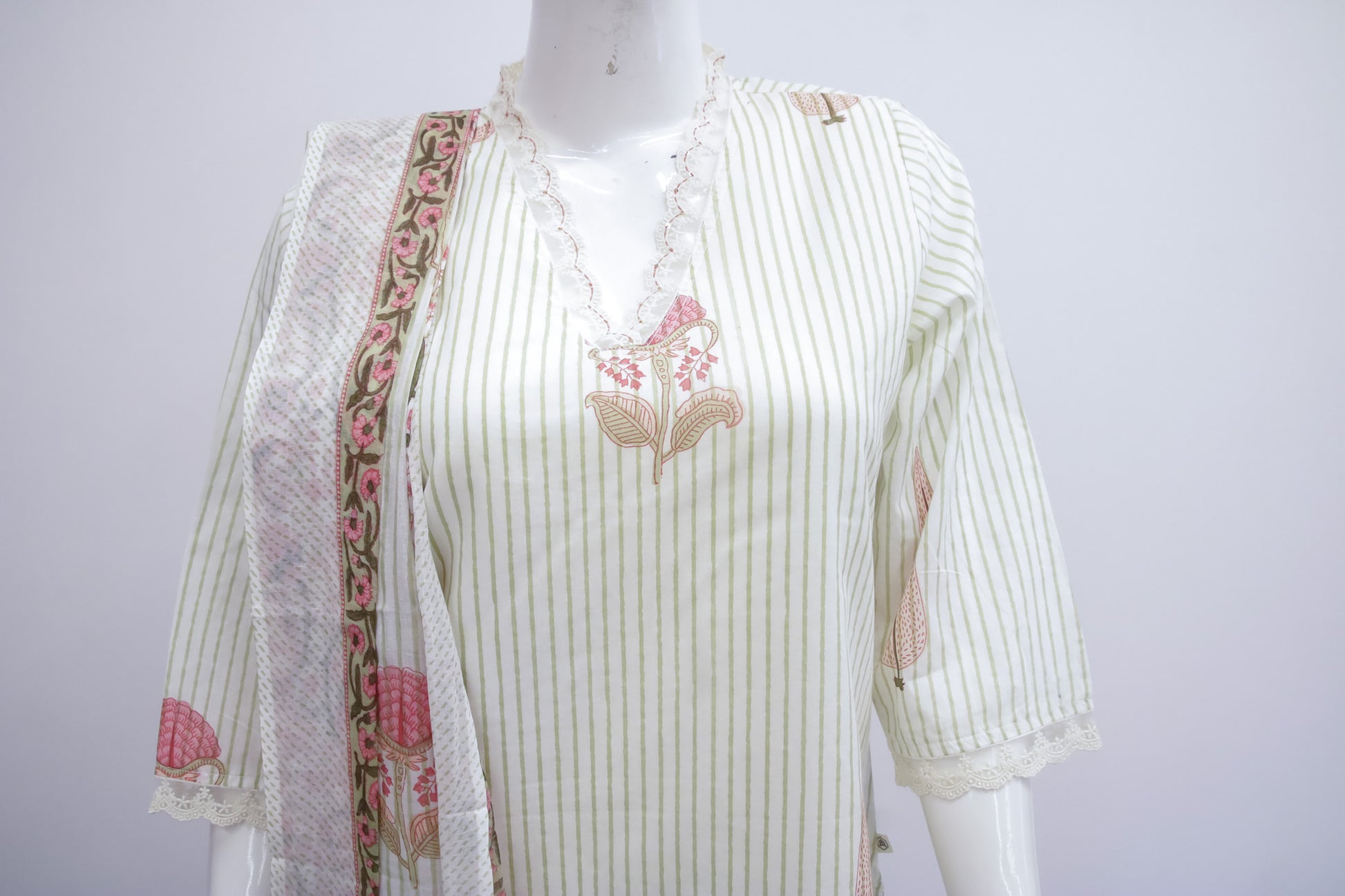 White striped shirt with floral embroidery on a mannequin against a white background