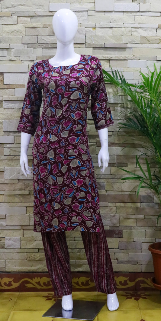 A mannequin displaying a capsule rayon top and pant set with floral prints in a dark wine color.