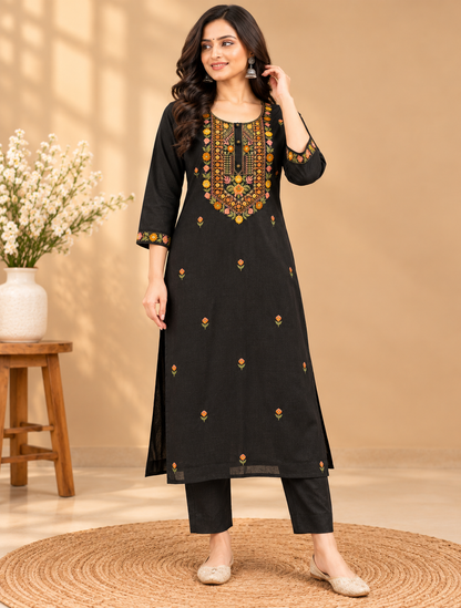 Black women's embroidered kurta pant set featuring colourful floral embroidery on the neckline and three-quarter sleeve borders, with small floral motifs throughout, by Udojas Sutra.