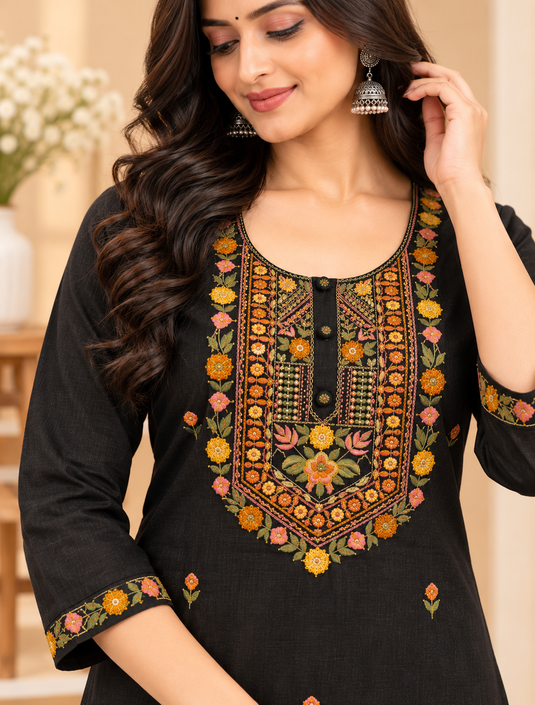 Black women's embroidered kurta pant set featuring colourful floral embroidery on the neckline and three-quarter sleeve borders, with small floral motifs throughout, by Udojas Sutra.