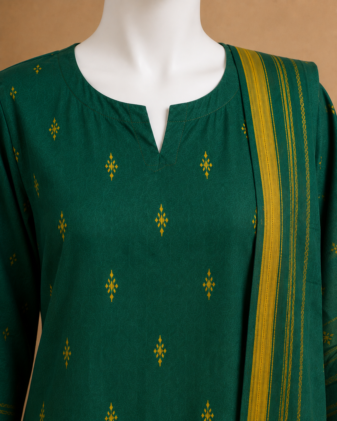 A dark green kurta with small yellow geometric motifs and a matching yellow striped dupatta, displayed on a white mannequin torso against a warm brown background.