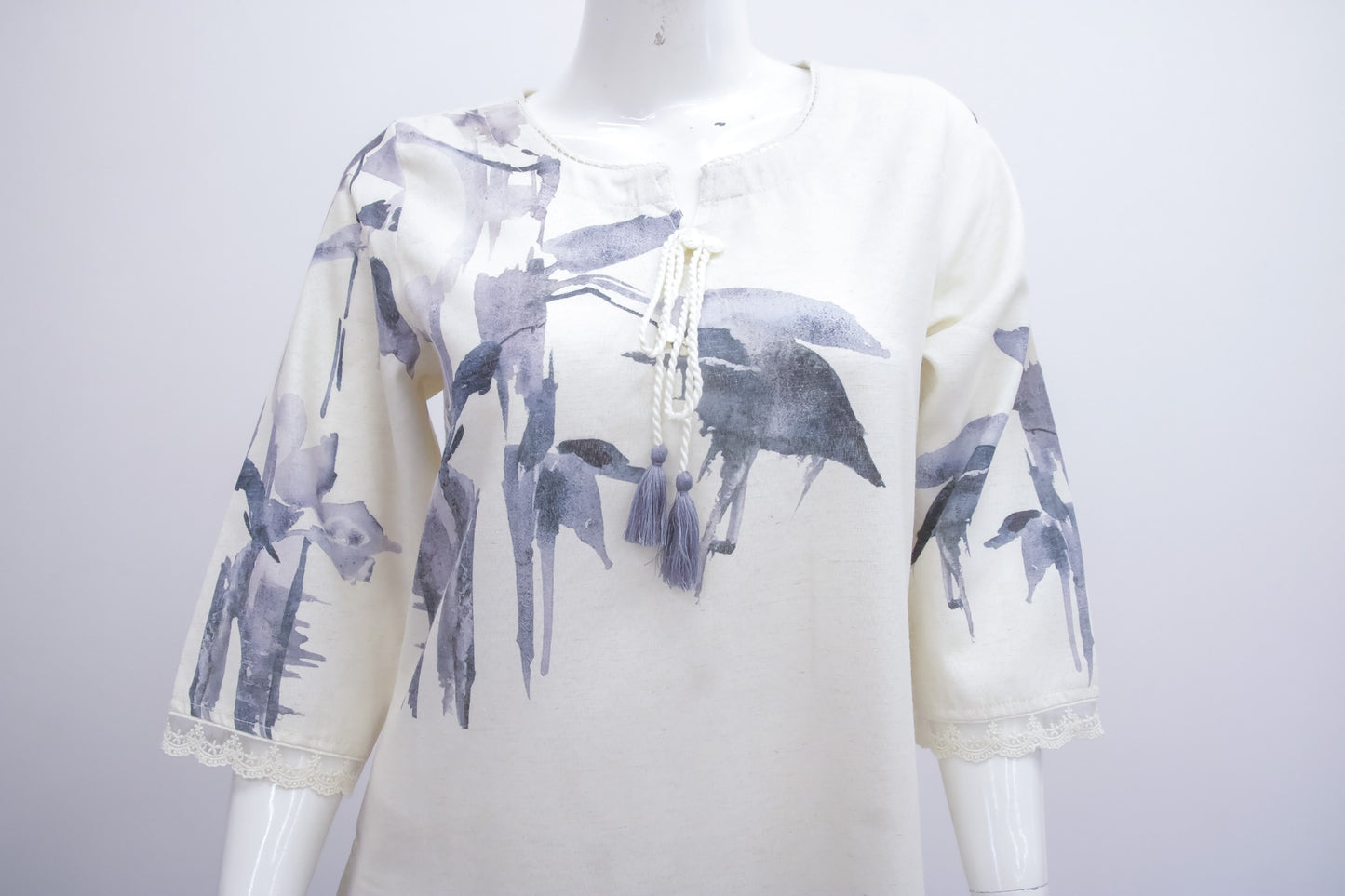 White hoodie with black bird patterns on a mannequin against a white background