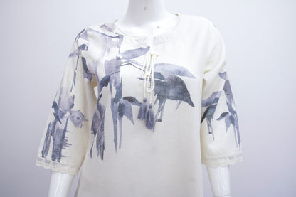 White hoodie with black bird patterns on a mannequin against a white background
