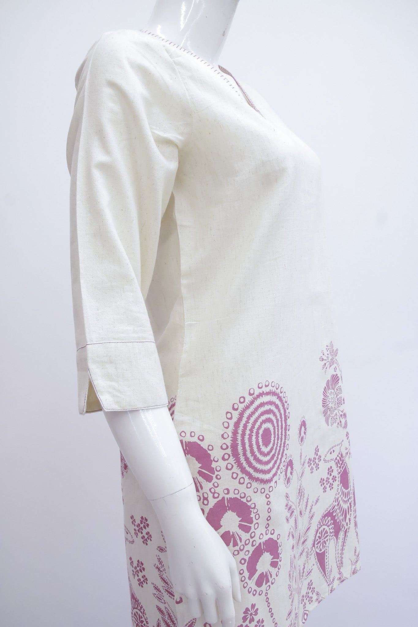 White dress with pink floral pattern on a white background