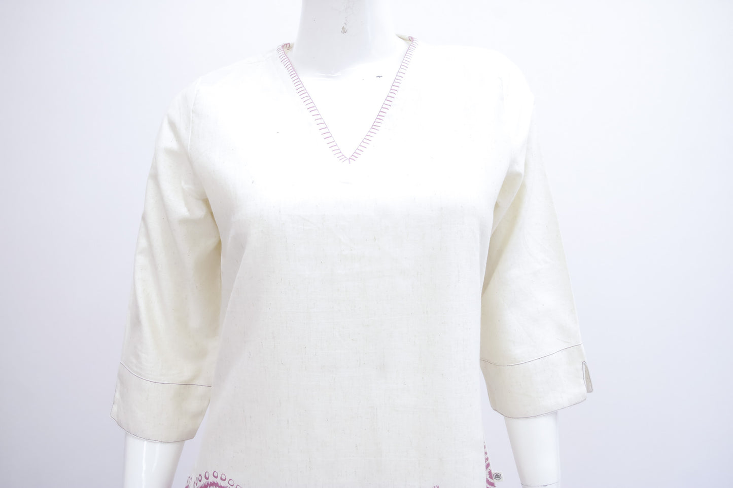 Mannequin wearing a cream-colored sweater on a white background