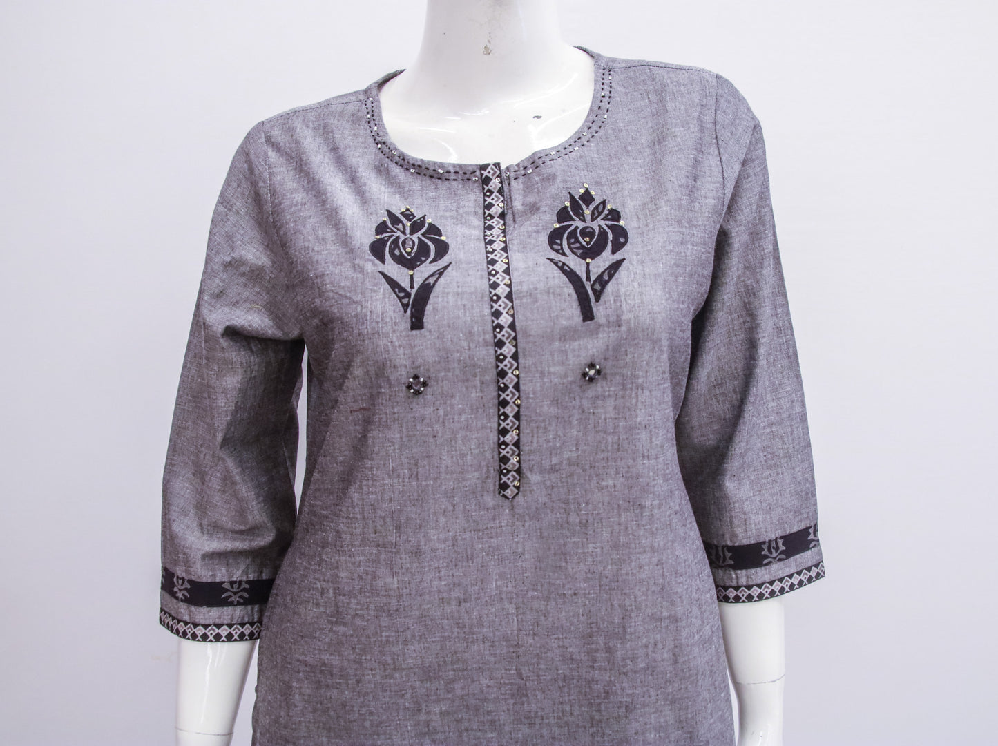Gray kurta with black floral embroidery on a mannequin against a white background