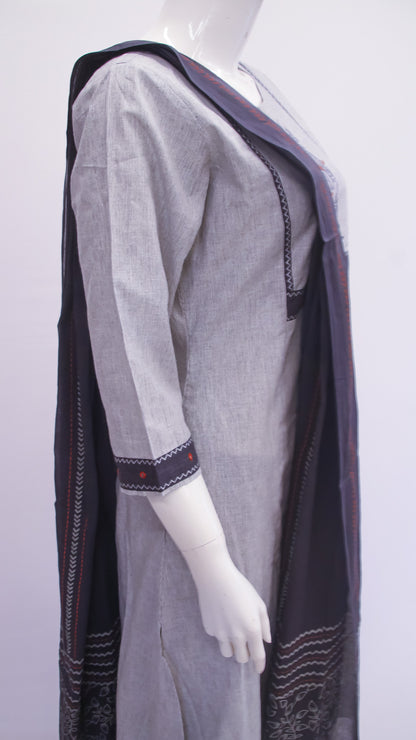 Mannequin wearing a gray dress with a black shawl on a white background