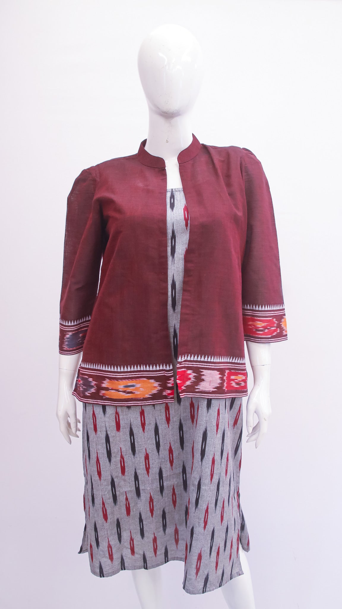 Maroon jacket with patterned skirt on a mannequin against a white background