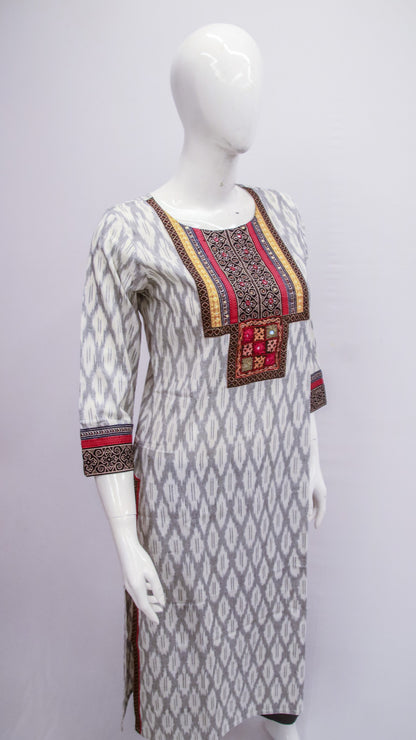 White kurta with black and red patterns on a mannequin against a gray background
