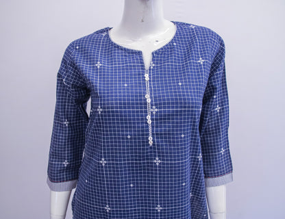 Blue checkered dress with white floral patterns on a mannequin against a light gray background