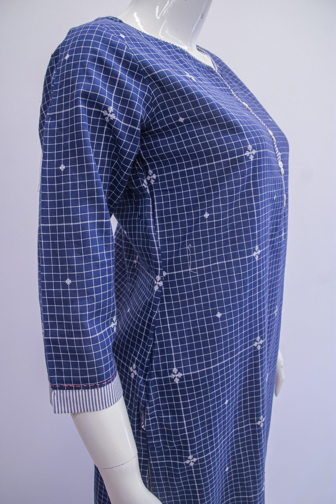 Mannequin wearing a blue grid-patterned dress on a white background
