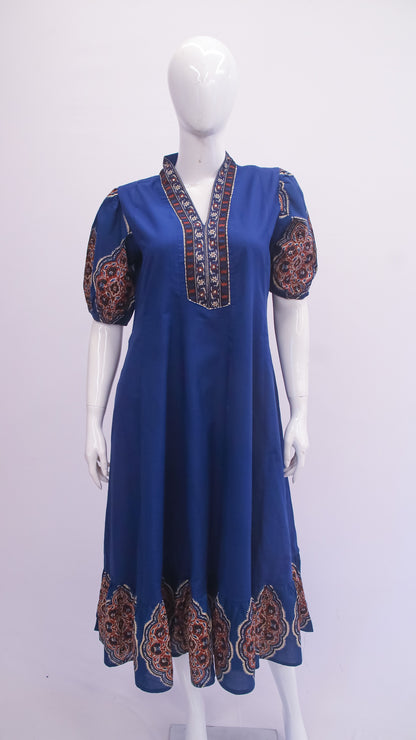 Blue dress with patterned sleeves on a mannequin against a white background