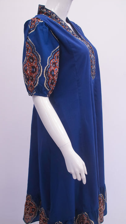 Blue dress with patterned sleeves on a mannequin against a white background