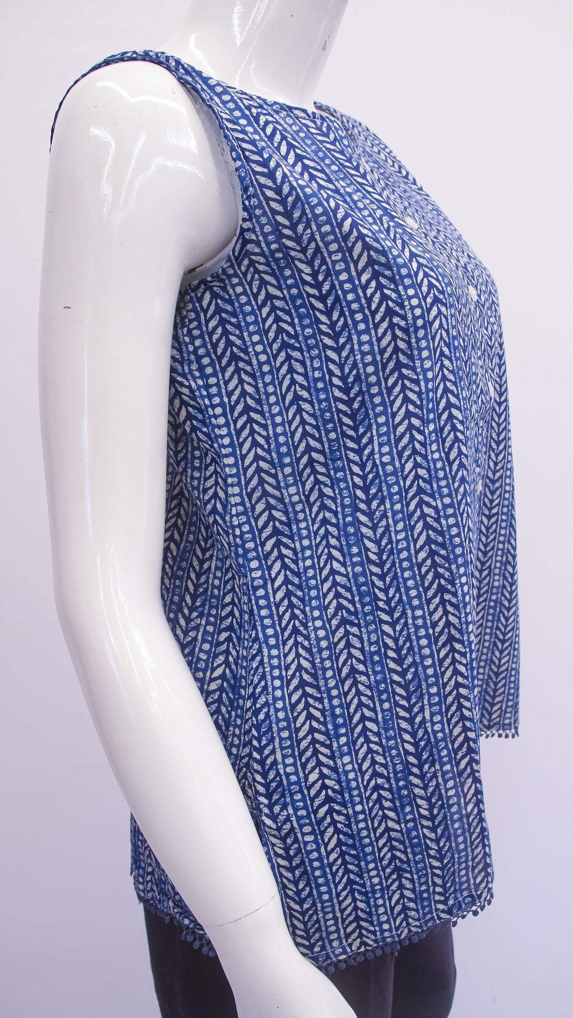 Mannequin wearing a blue patterned top on a white background