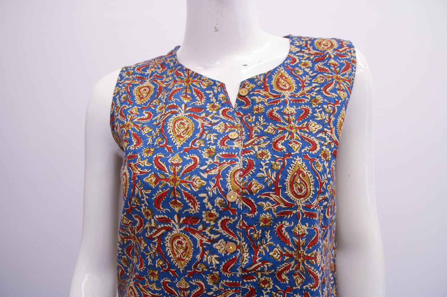Colorful patterned sleeveless top on a mannequin against a white background