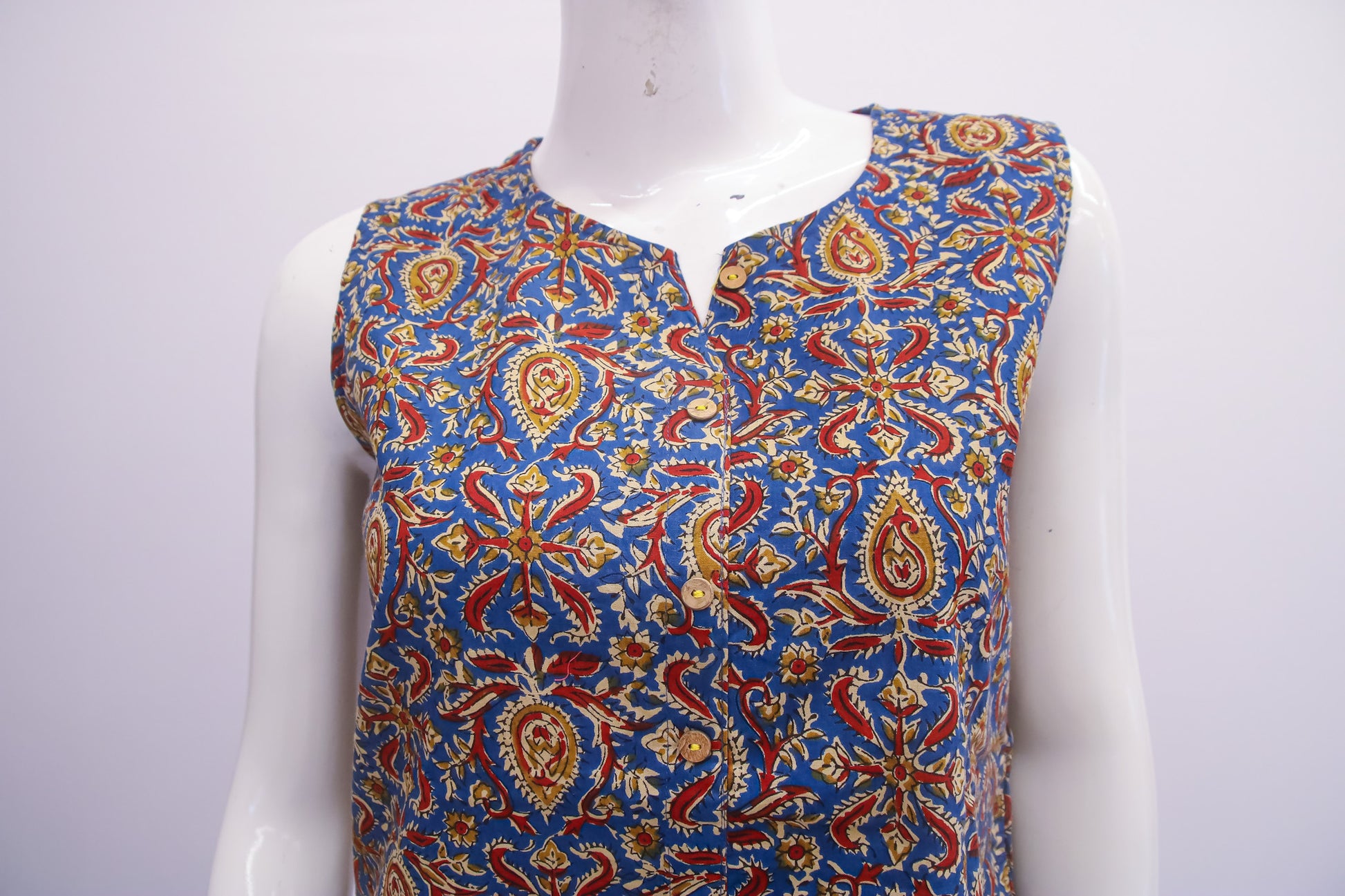 Colorful patterned sleeveless top on a mannequin against a white background