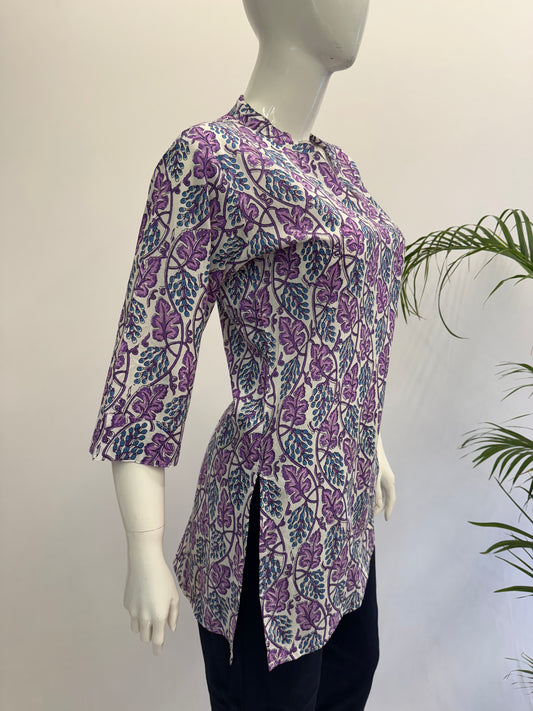 Mannequin wearing a purple floral patterned shirt with a white background