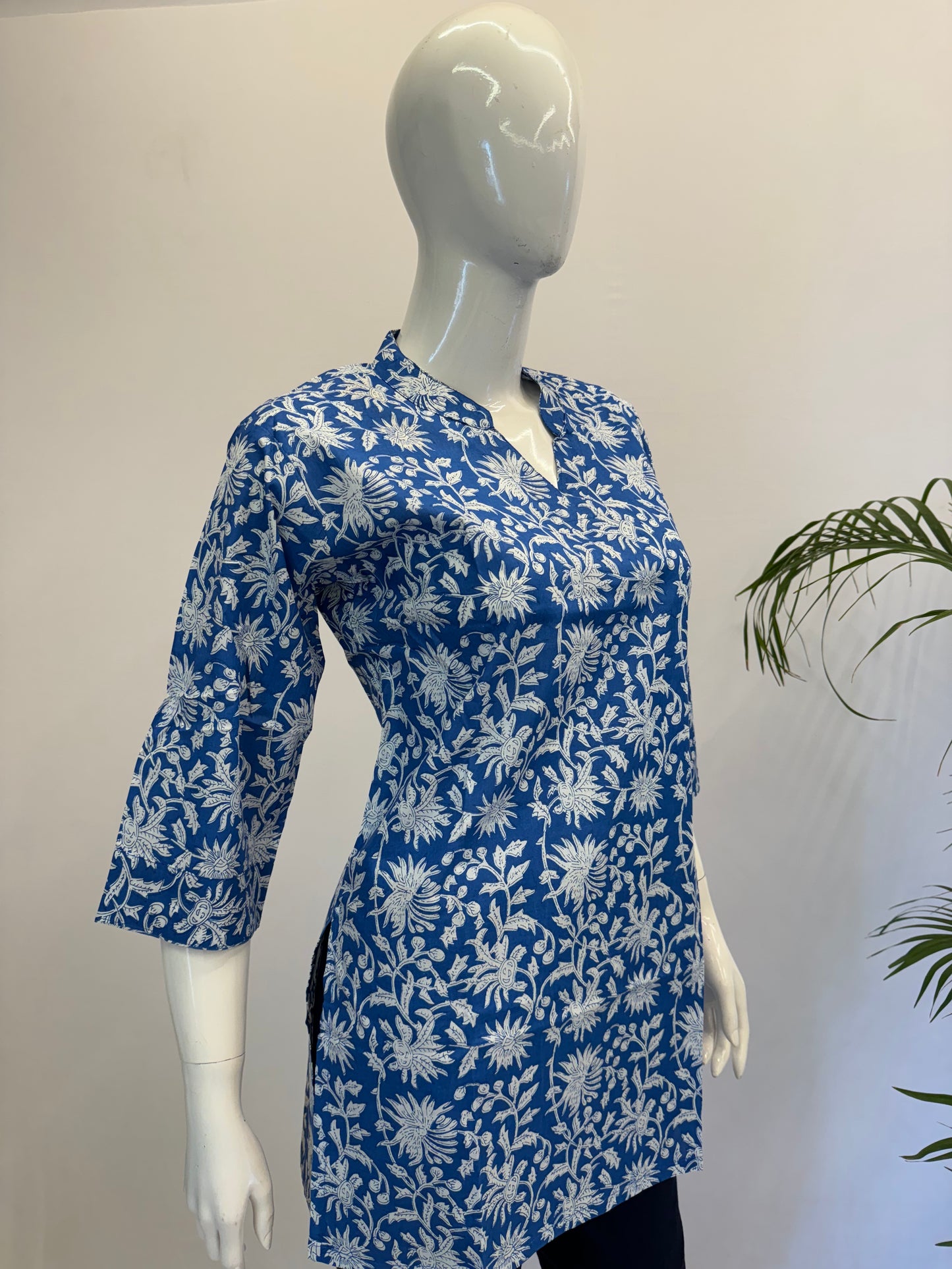 Mannequin wearing a blue floral patterned shirt against a plain background