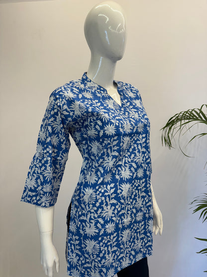 Mannequin wearing a blue floral patterned shirt against a plain background