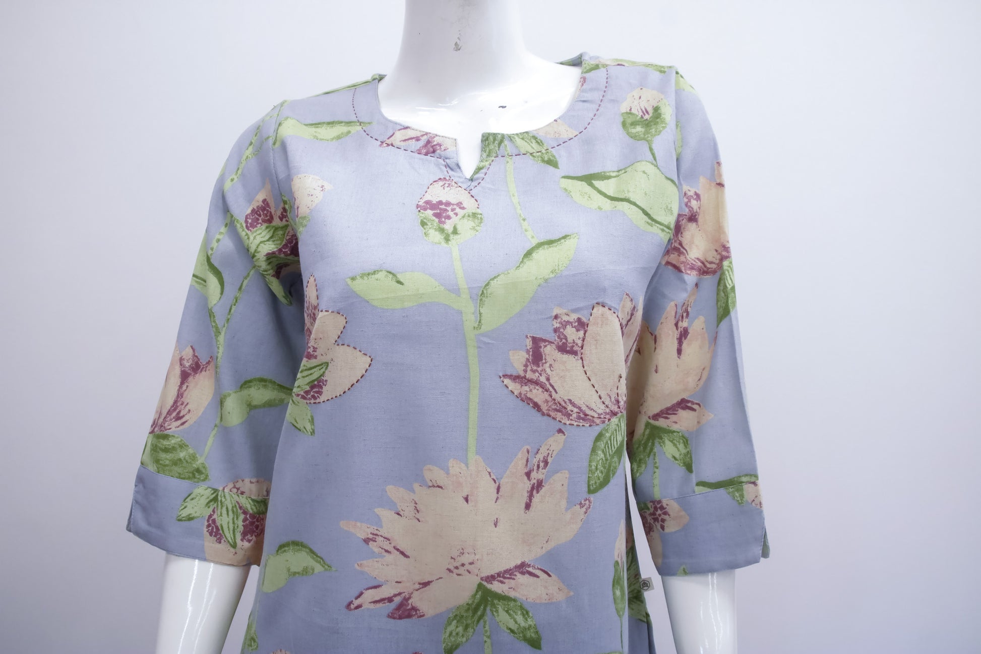 Floral-patterned shirt on a mannequin against a white background