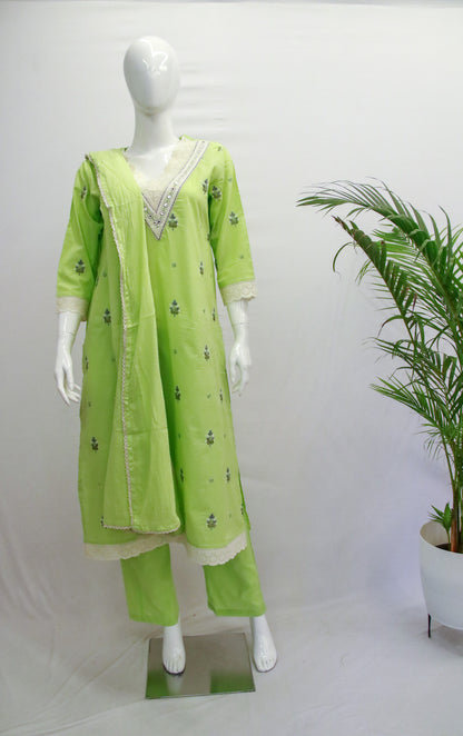 A mannequin displaying a green dupatta set with embroidery, consisting of a kurta, pant, and dupatta, against a white background with a potted plant beside it.