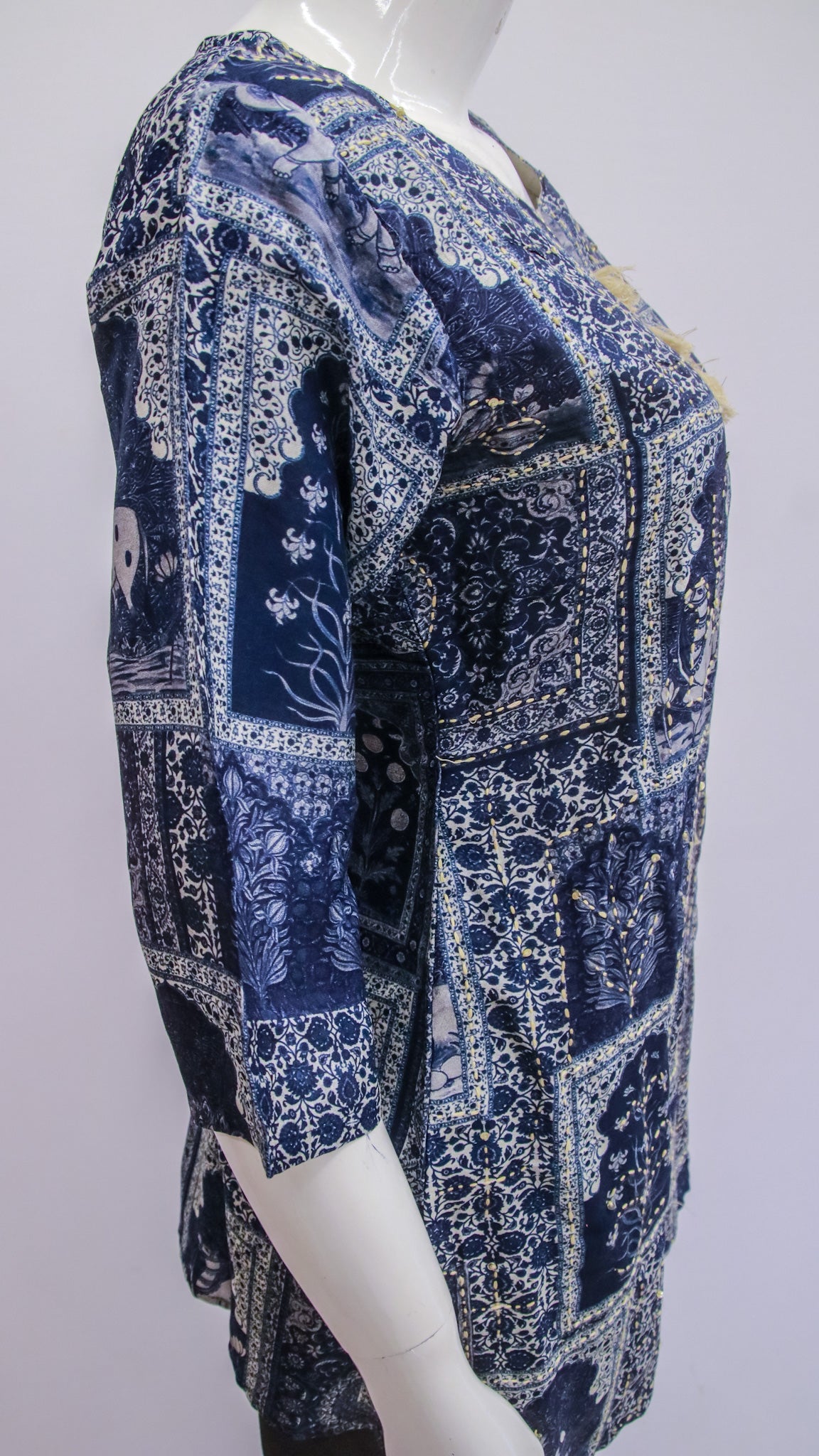 Mannequin wearing a blue patterned dress against a white background