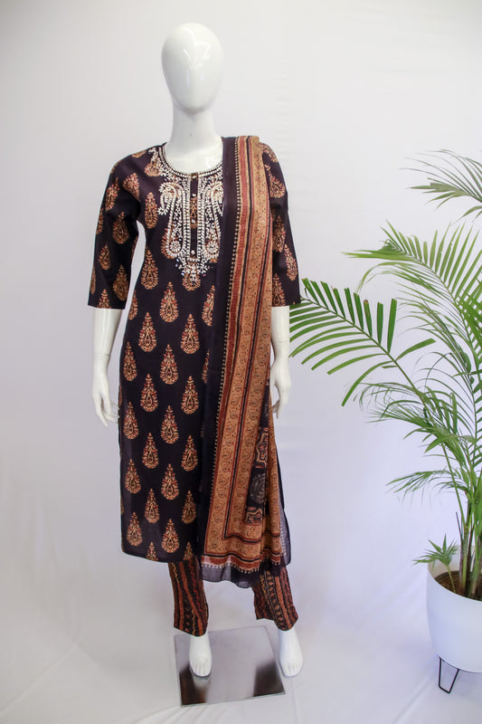 A mannequin displaying a navy blue cotton three-piece suit with floral print, consisting of a kurta, pants, and a dupatta.