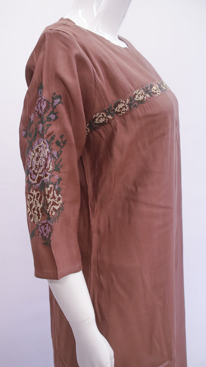 Brown dress with floral embroidery on a mannequin against a white background