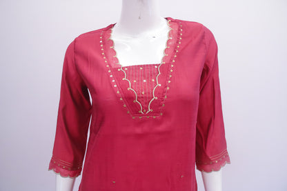 Red kurta with gold embroidery on a mannequin against a white background