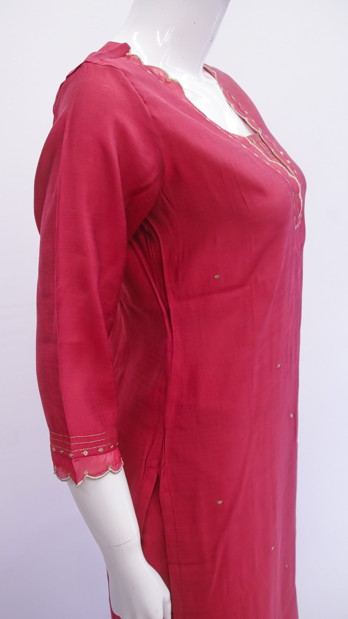 Red dress with lace details on a mannequin against a white background